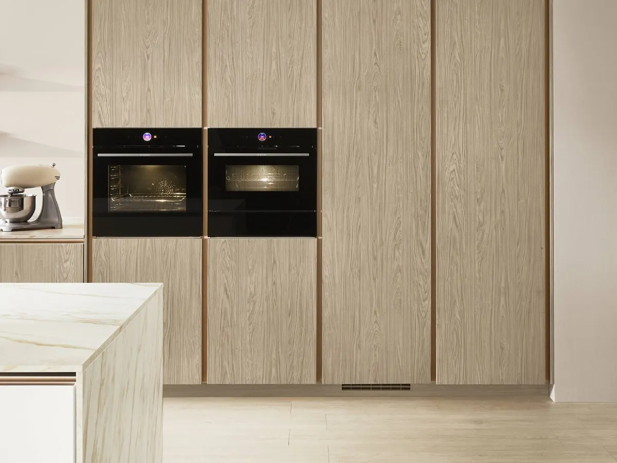 Oak-grain tall units with twin ovens beside an island