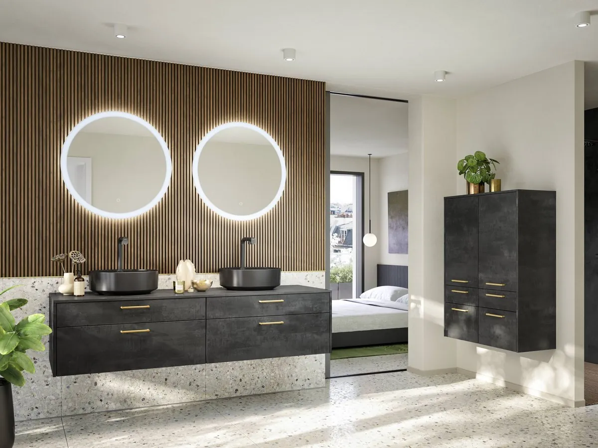 A double vanity in dark stone-effect fronts under two round lit mirrors