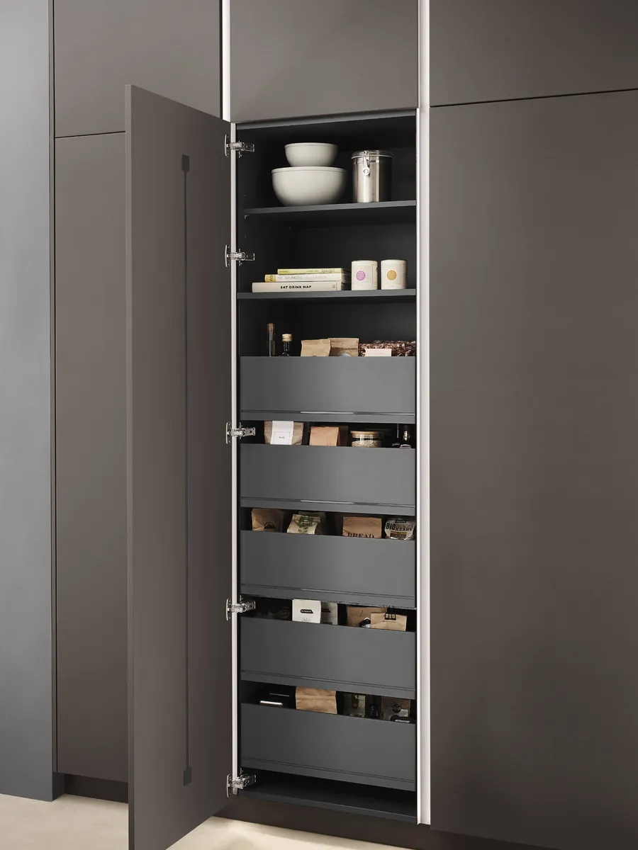 A dark tall unit with its door open on a stack of internal drawers